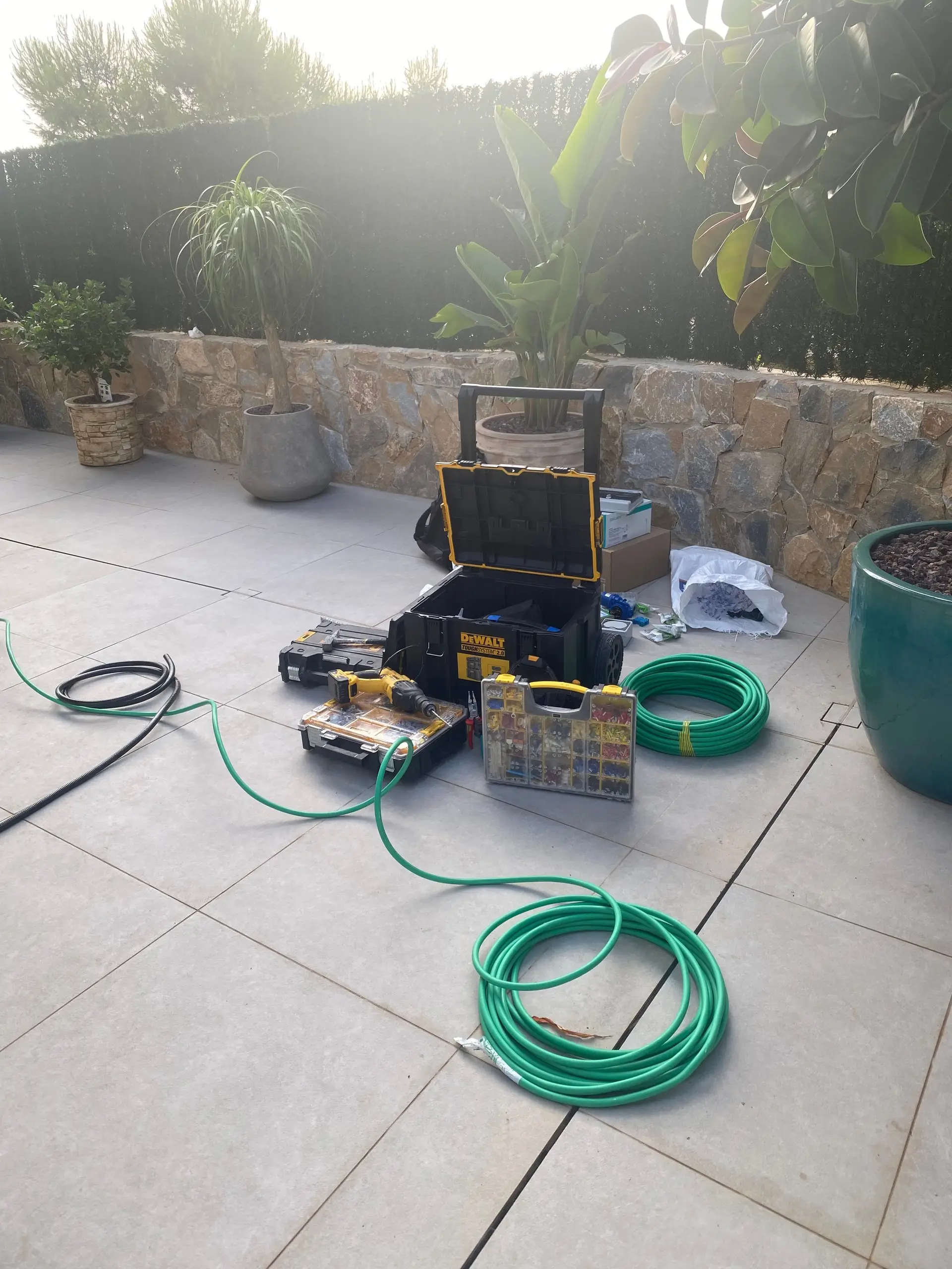 Tools and cable drums laid out on a house terrace before the installation starts