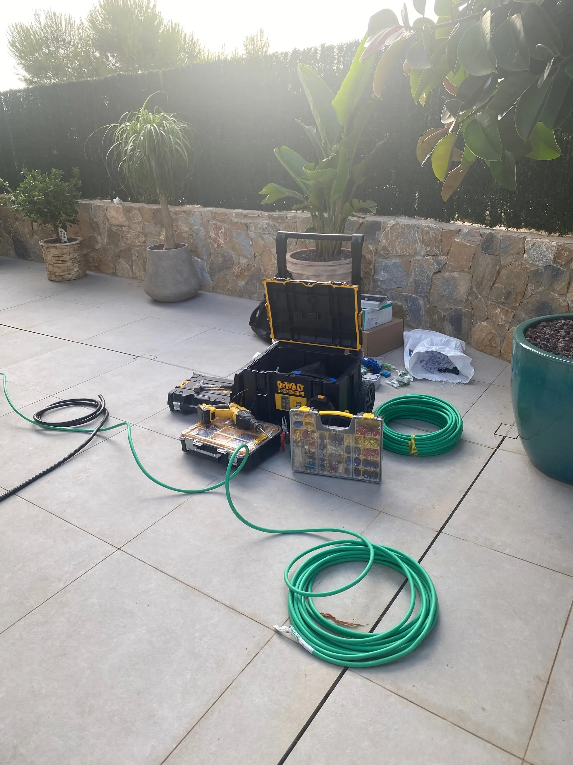 Tools and cable drums laid out on a house terrace before the installation starts