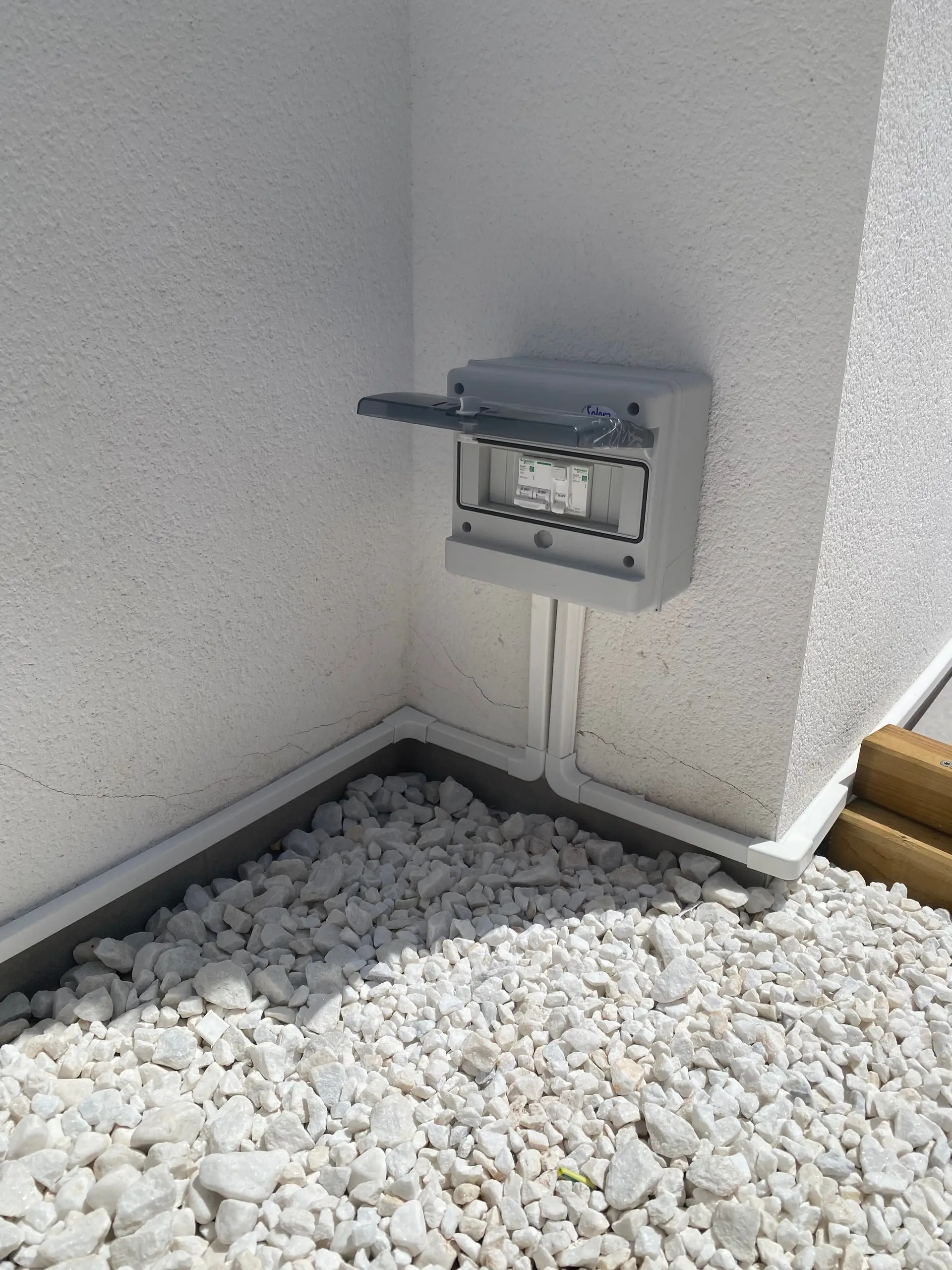 Caja estanca de superficie cerrada con dos aparatos de protección y canalización blanca en el rincón
