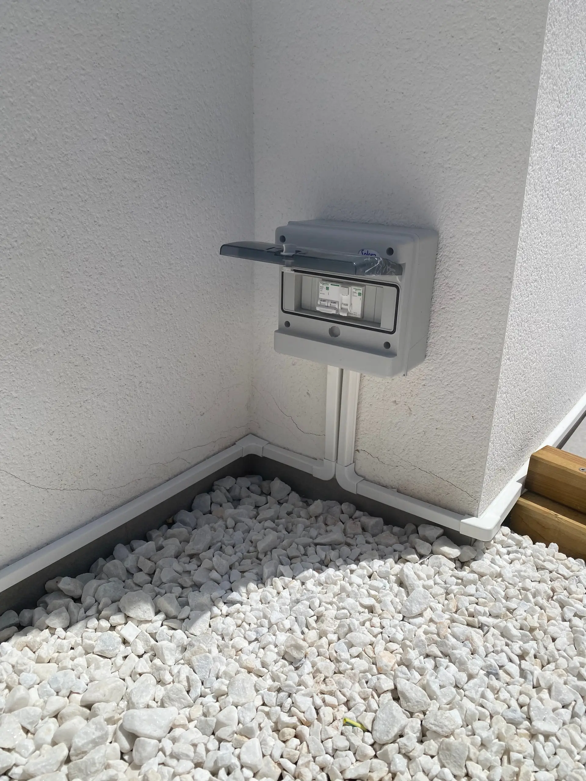Closed surface-mounted weatherproof enclosure with two protective devices and white containment in the corner