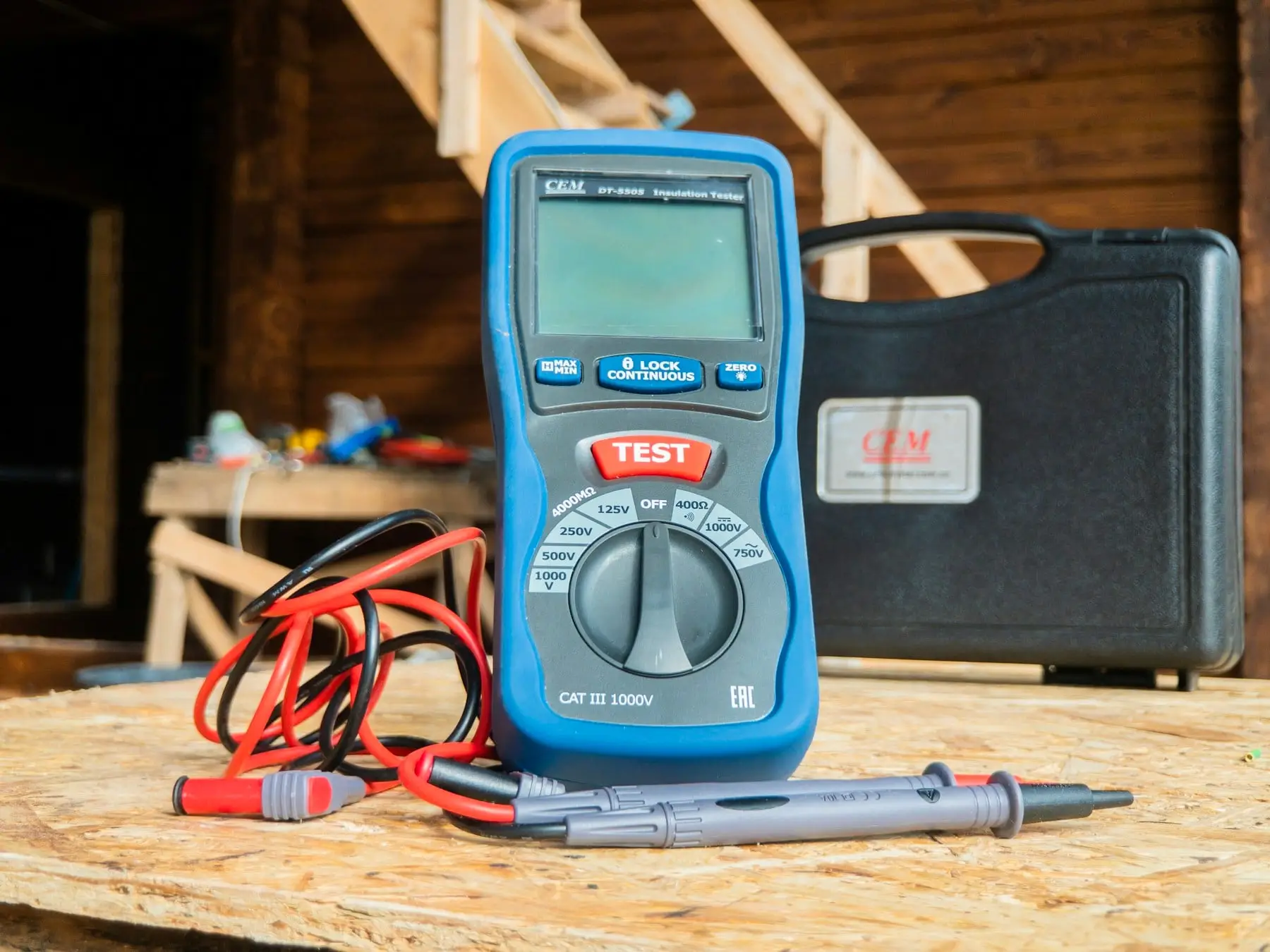 Insulation resistance tester with its test leads on a workbench